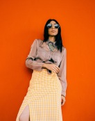 a person wearing sunglasses with orange wall